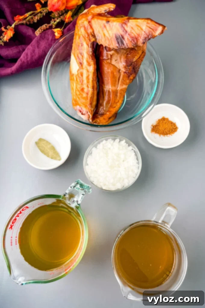 Classic Southern Black Eyed Peas and Smoked Turkey 3 An array of fresh ingredients for Southern Black Eyed Peas, including smoked turkey, a bowl of rich broth, chopped onions, Creole seasoning, and a bay leaf.