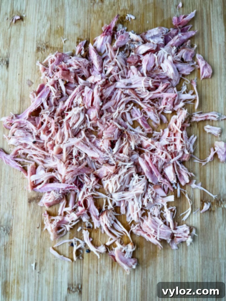 Classic Southern Black Eyed Peas and Smoked Turkey 7 Shredded smoked turkey meat on a bamboo cutting board, ready to be incorporated into the cooked black eyed peas.