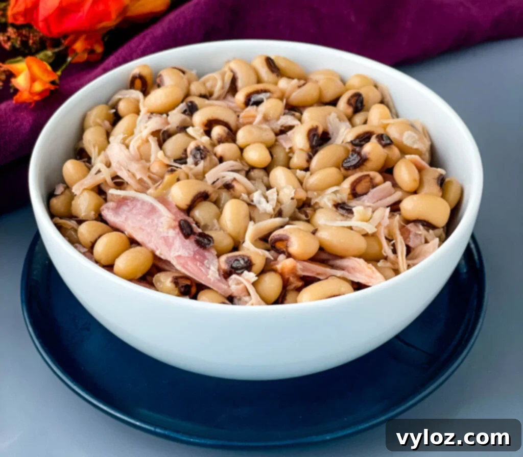 Classic Southern Black Eyed Peas and Smoked Turkey 8 A serving of Southern black eyed peas in a white bowl, garnished with a piece of smoked turkey.