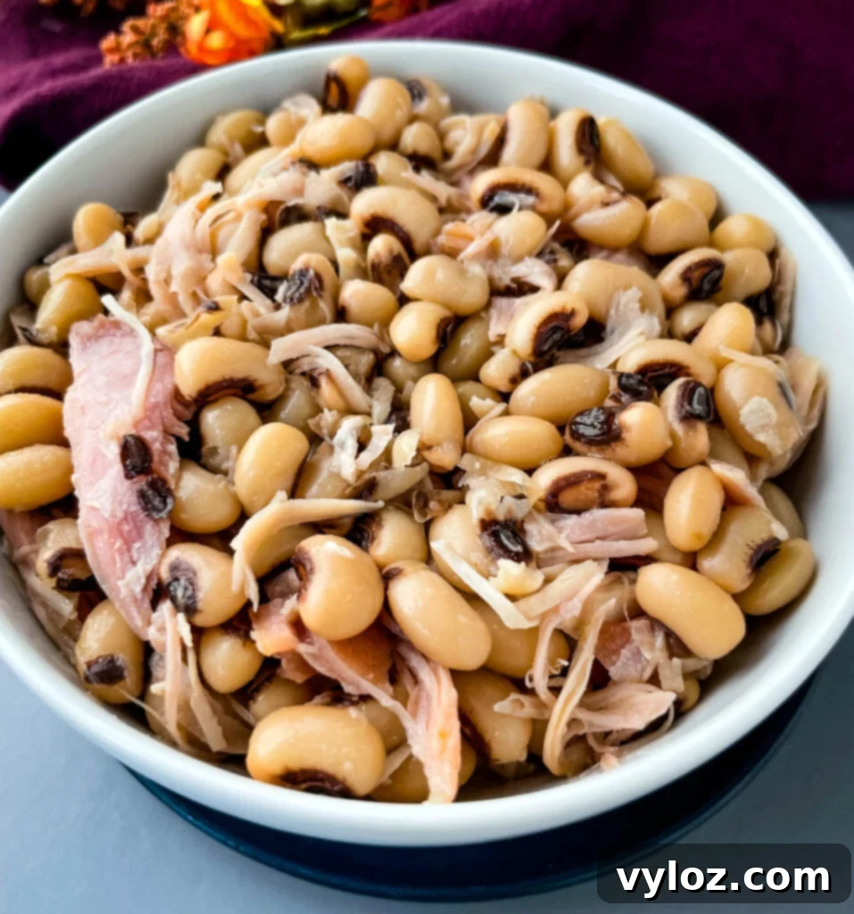 Classic Southern Black Eyed Peas and Smoked Turkey 10 A beautifully plated serving of Southern black eyed peas with shredded smoked turkey in a white bowl, ready to be enjoyed.