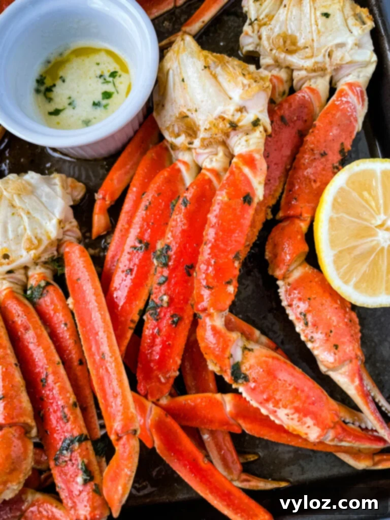 Decadent Garlic Butter Crab 8 baked crab legs on a pan with lemon garlic butter