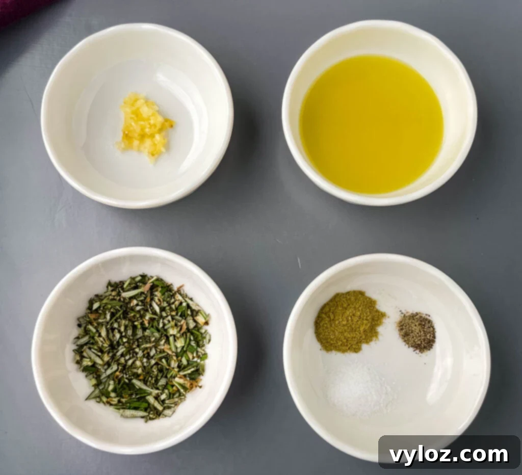 Close-up of fresh garlic, olive oil, rosemary, and oregano in white bowls, essential ingredients for seasoning lamb.