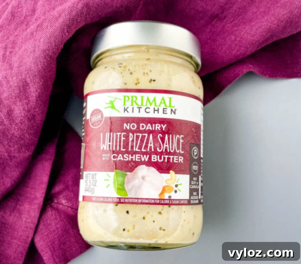 A jar of Primal Kitchen No-Dairy White Pizza Sauce, highlighting its clean ingredients and premium quality.