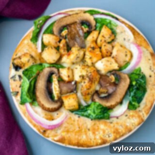 pita bread pizza with spinach, chicken, mushrooms, and onions