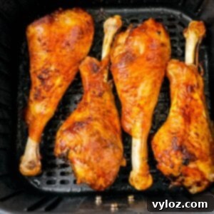 Crispy turkey legs being cooked to perfection in an air fryer, with a golden-brown finish.