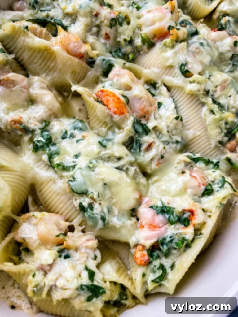 Seafood lobster, shrimp, and crab stuffed shells in a baking dish, garnished with fresh herbs, showcasing the rich, cheesy top layer.