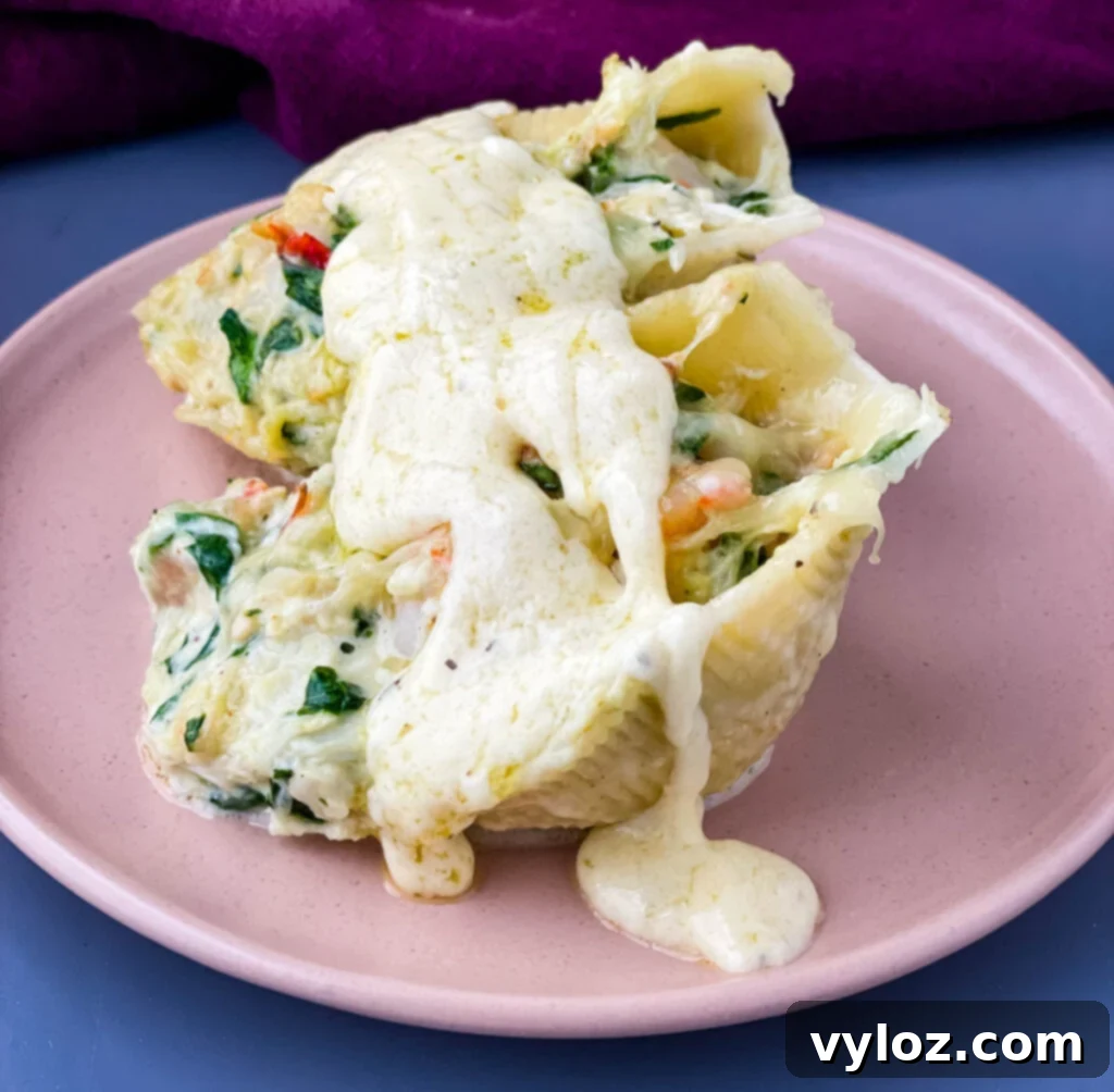 A plate of seafood stuffed shells, featuring lobster, shrimp, and crab, drizzled with extra sauce and garnished with fresh herbs, ready to be enjoyed.