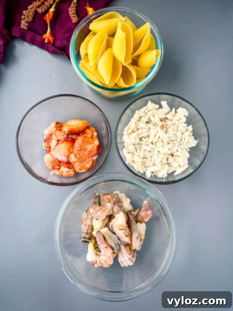 Uncooked jumbo pasta shells, alongside bowls of fresh lobster, shrimp, and lump crab meat, ready for preparation.