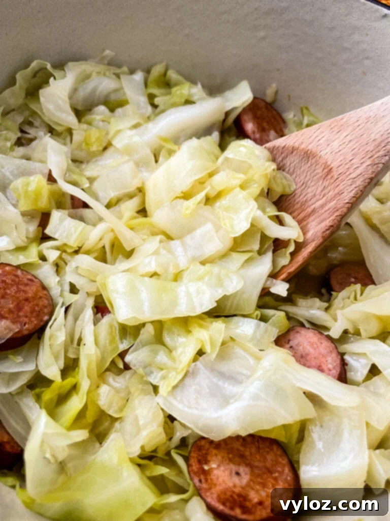 southern soul food cooked cabbage in a large pot with a wooden spoon