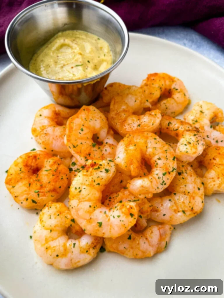 Crispy Air Fryer Frozen Shrimp 8 Cooked air fryer frozen shrimp on a plate with sauce