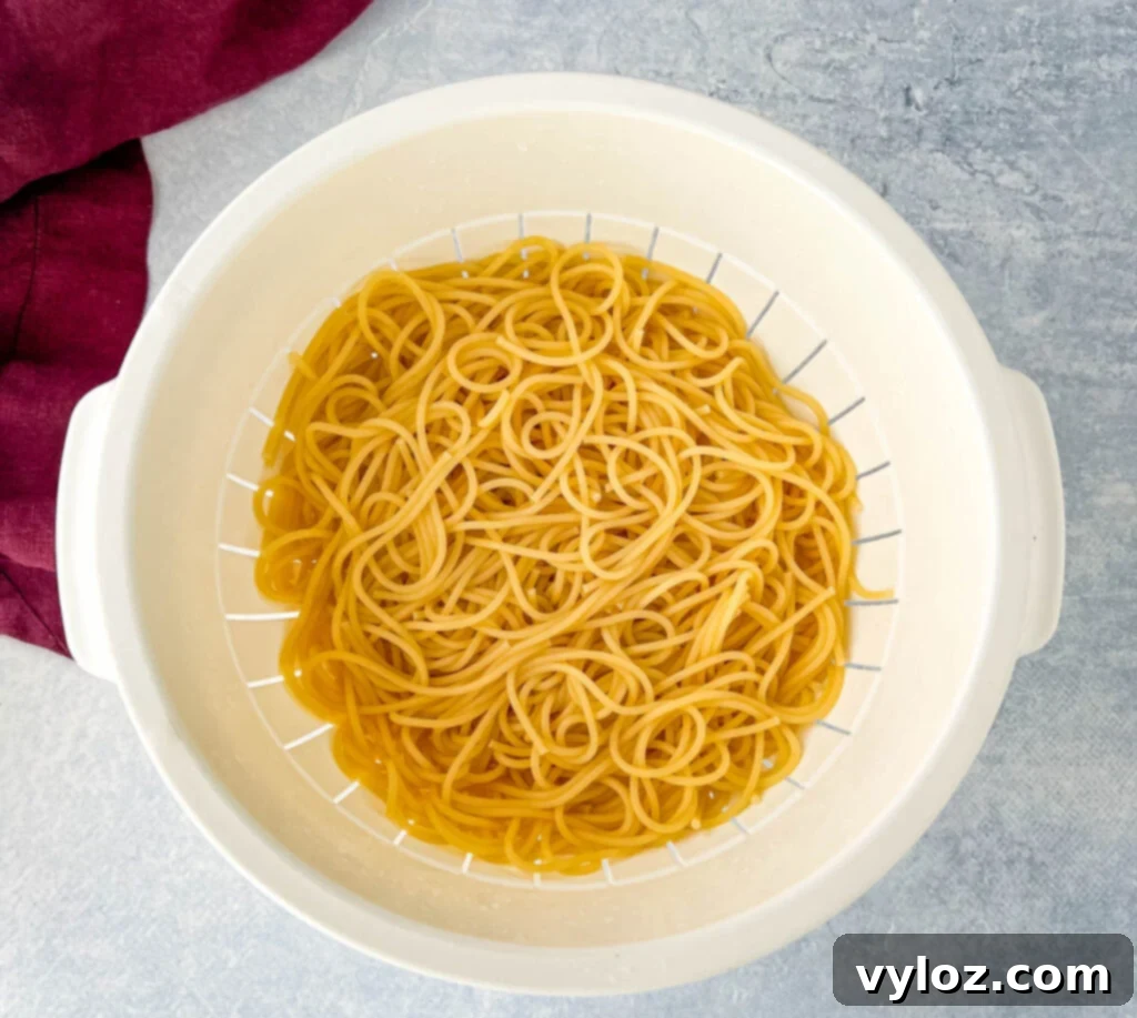 cooked spaghetti pasta in a colander, freshly drained