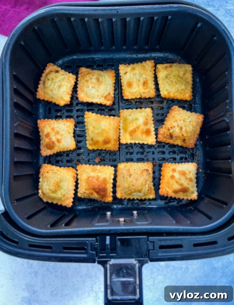 Crispy toasted fried ravioli fresh out of the air fryer, piled in a basket