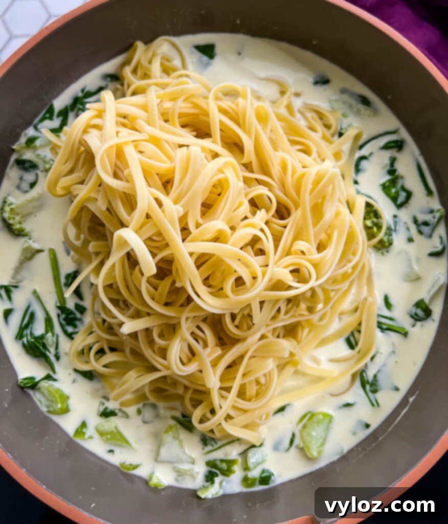 Creamy lemon chicken pasta tossed together in a large pan, ready to be served.