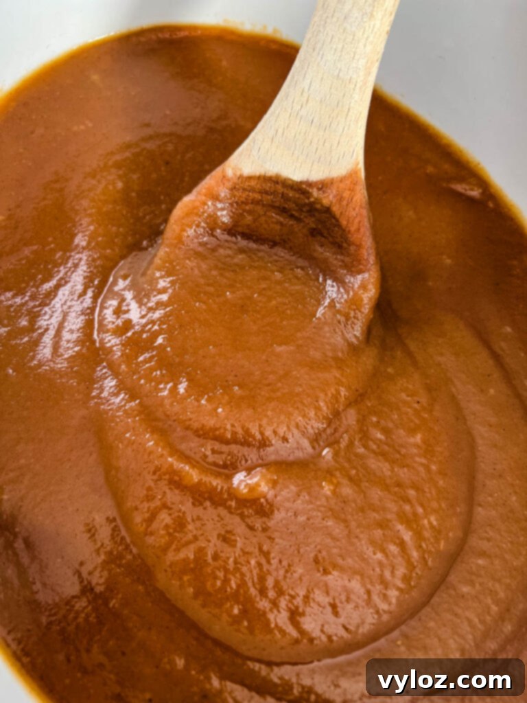Wholesome Apple Butter 2 sugar free apple butter in a slow cooker with a wooden spoon