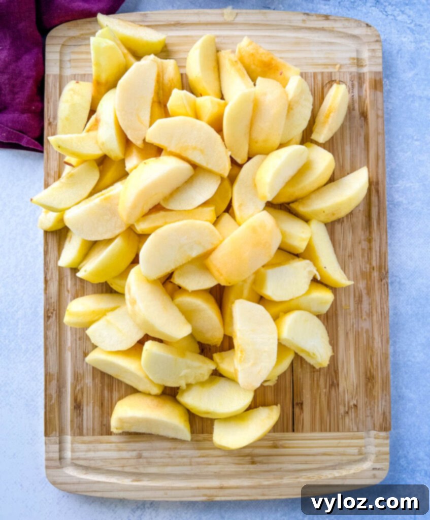 Wholesome Apple Butter 5 sliced apples on a bamboo cutting boad