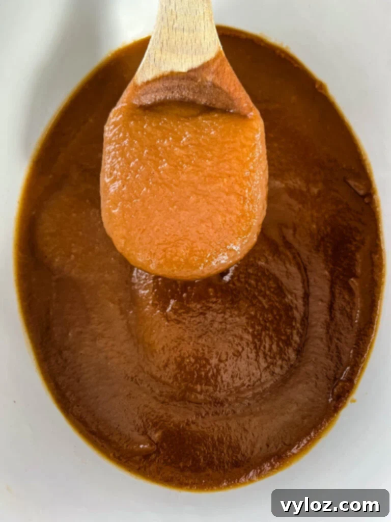 Wholesome Apple Butter 10 sugar free apple butter in a slow cooker with a wooden spoon