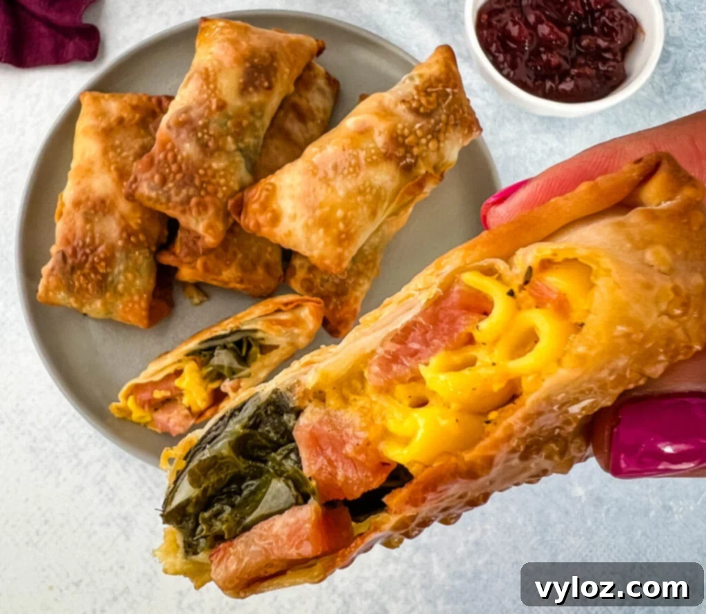 A person holding a Thanksgiving soul food egg roll, showcasing its perfect golden-brown crispness.