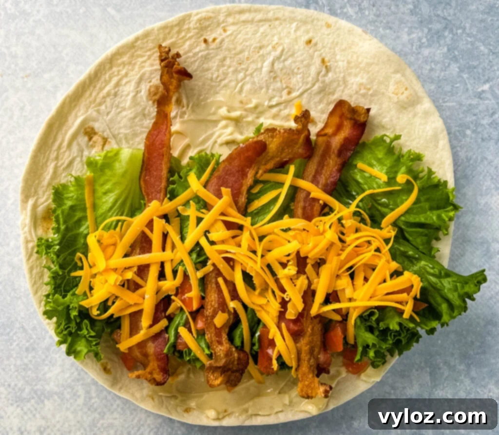 Quick BLT Wrap 4 blt wrap with bacon, lettuce, tomato, and mayo on a plate in a tortilla