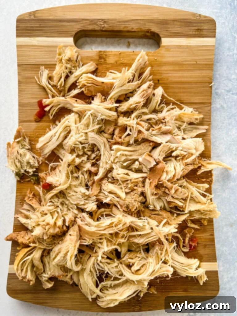 Perfectly shredded chicken on a cutting board, prepared for adding to the gumbo.