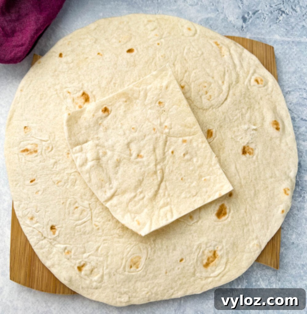 A large burrito-sized tortilla laid flat on a clean surface, ready for fillings.