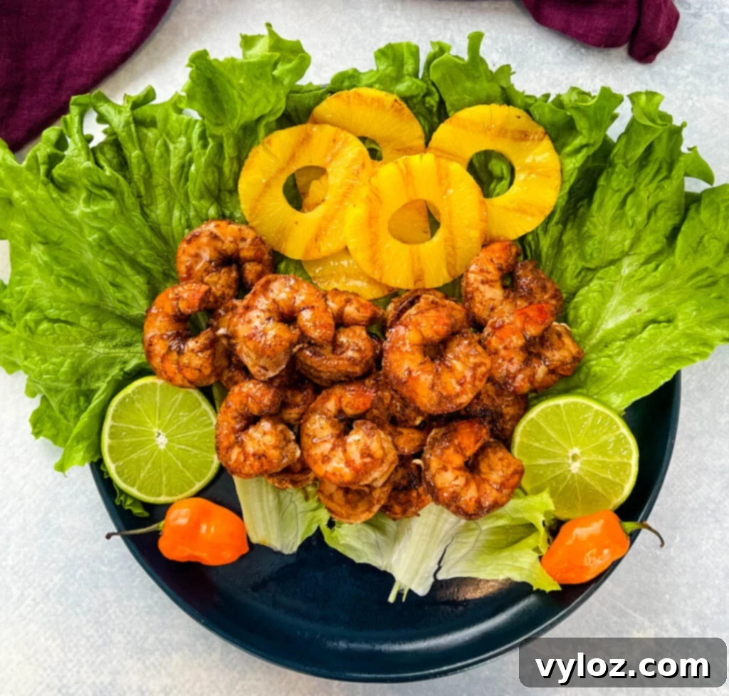 Effortless Caribbean Shrimp 2 jerk shrimp on lettuce with pineapples, limes, and fresh peppers