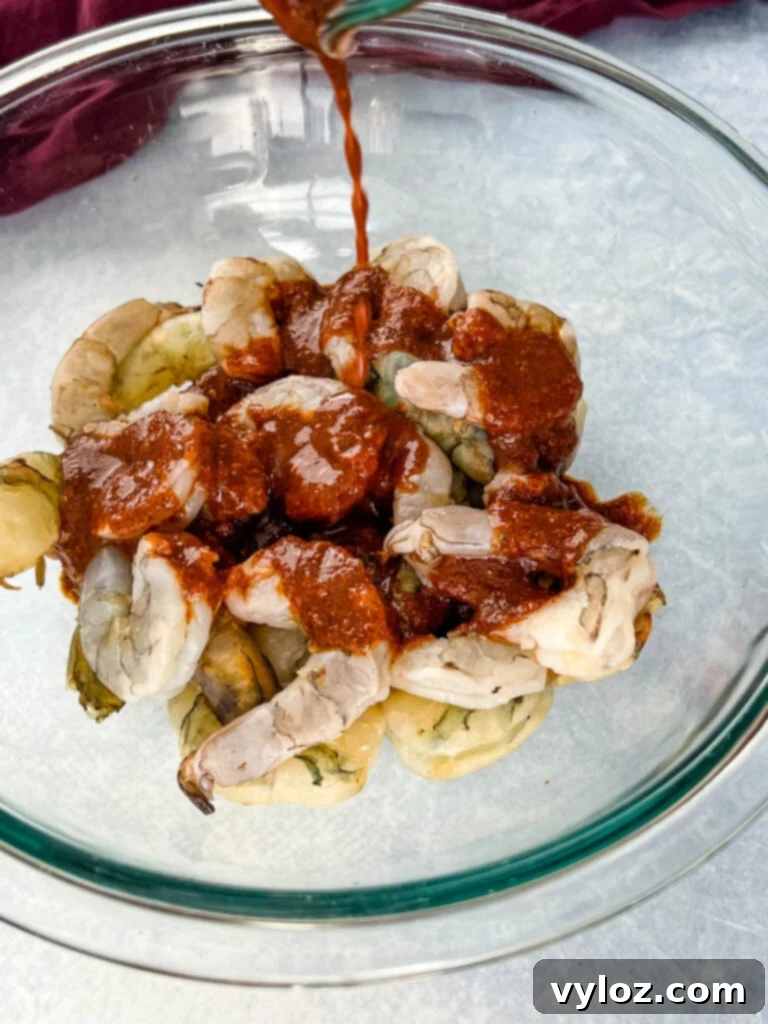 Effortless Caribbean Shrimp 8 raw shrimp in a glass bowl with jerk marinade