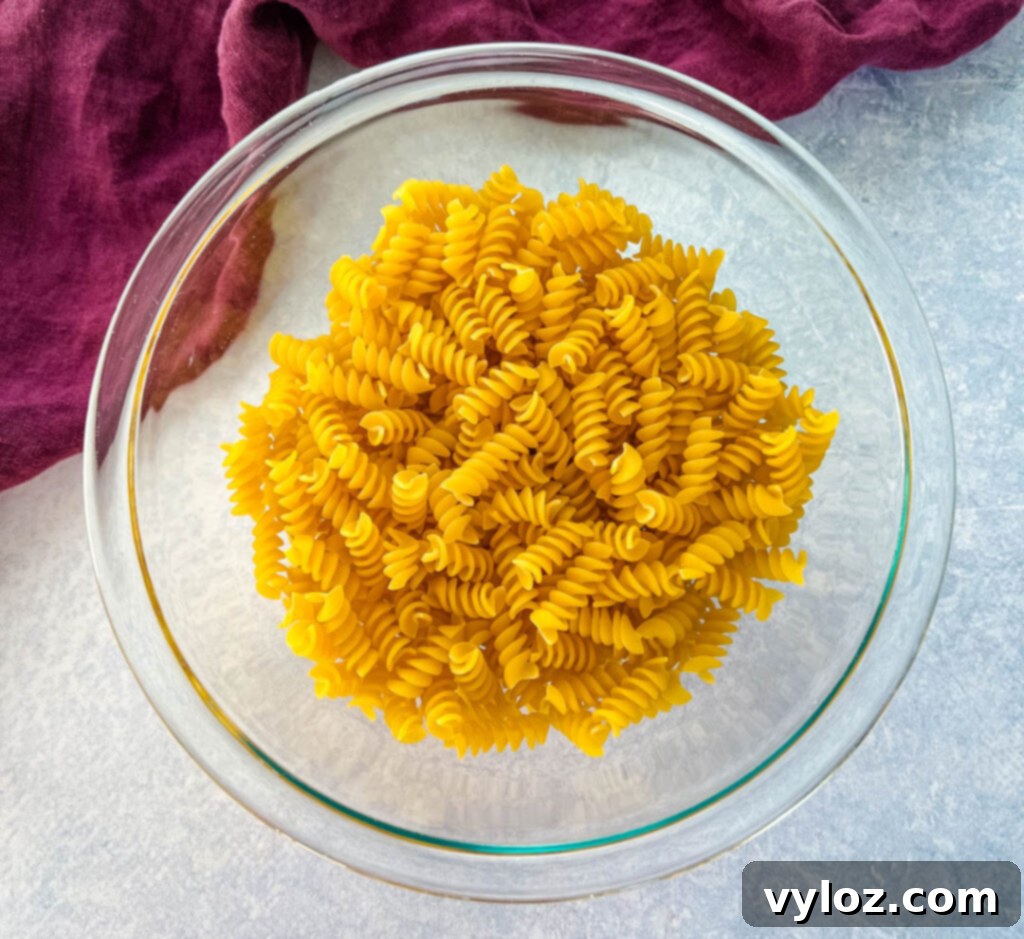uncooked rotini pasta in a glass bowl