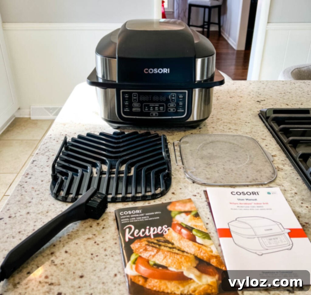 Contents of the Cosori Aeroblaze Indoor Grill box laid out on a kitchen counter, showing all included accessories.