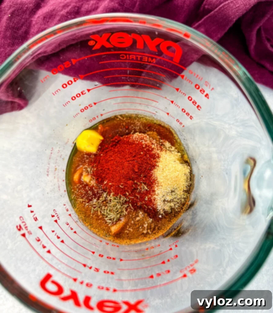 Bold Caribbean Jerk Marinade 5 Another view of the jerk marinade in a glass measuring cup, emphasizing its rich texture and color.