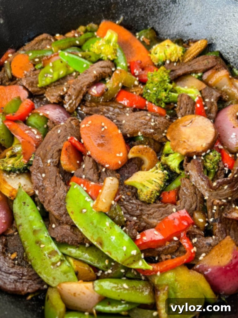 Sizzling Teriyaki Beef 6 Close-up of a sizzling beef and vegetable stir fry in a dark skillet, ready to serve