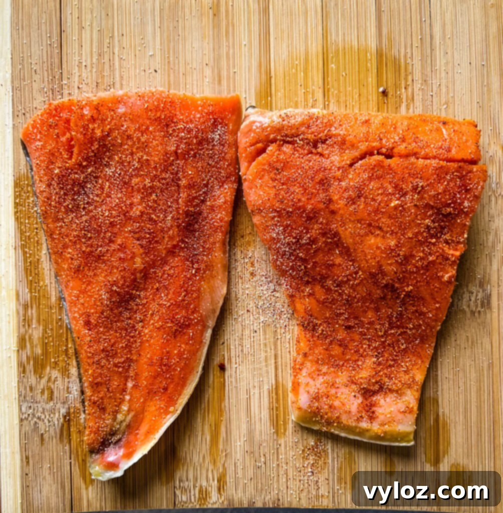 Ninja Foodi Grilled Salmon 4 Raw salmon fillets perfectly seasoned on a cutting board, ready for the indoor grill.