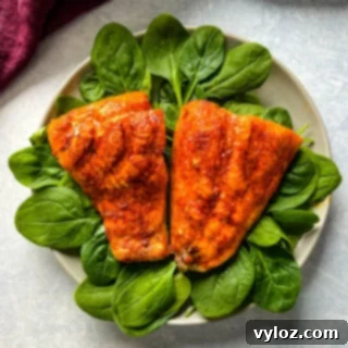 Ninja Foodi Grilled Salmon 10 Cooked indoor grilled salmon on a plate with fresh spinach