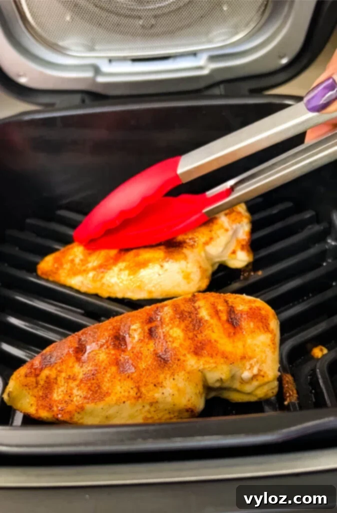 Grilled chicken breast with visible grill marks, sliced on a cutting board