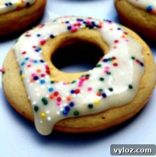 4 vanilla protein donuts on a white plate with sprinkles