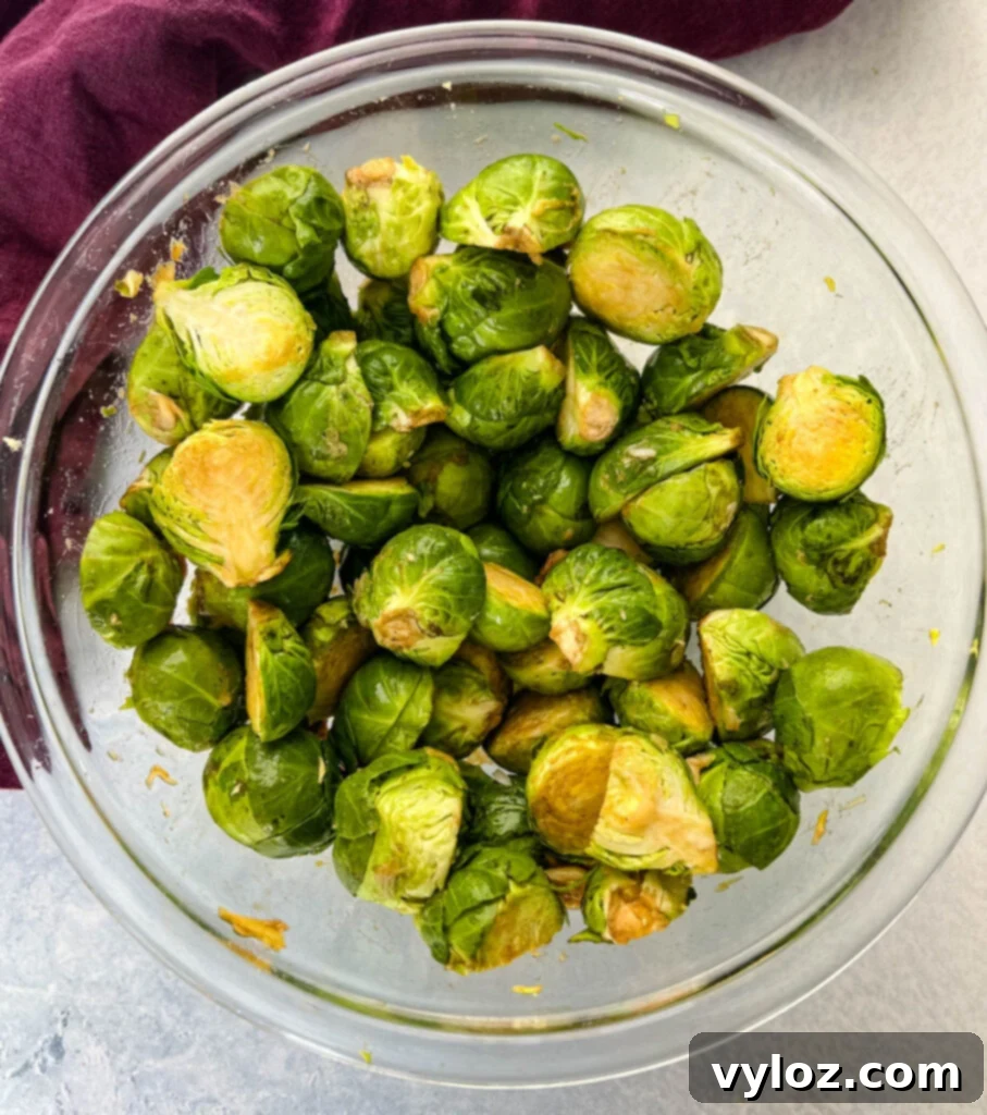 Caramelized Garlic Brussels Sprouts 7 Seasoned raw Brussels sprouts in a glass bowl with garlic and balsamic vinegar, coated evenly