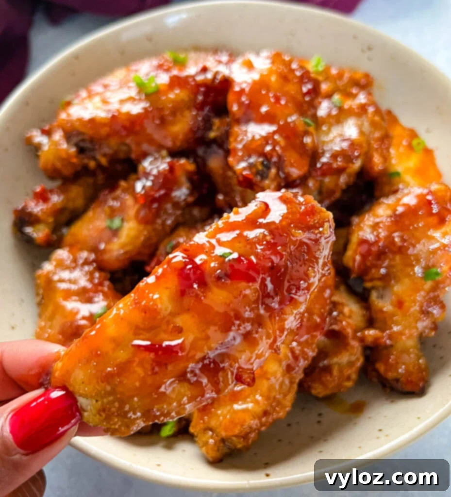 Sweet Chili Chicken Wings: A Flavorful Journey 12 person holding sweet chili chicken wing, showing its sticky glaze