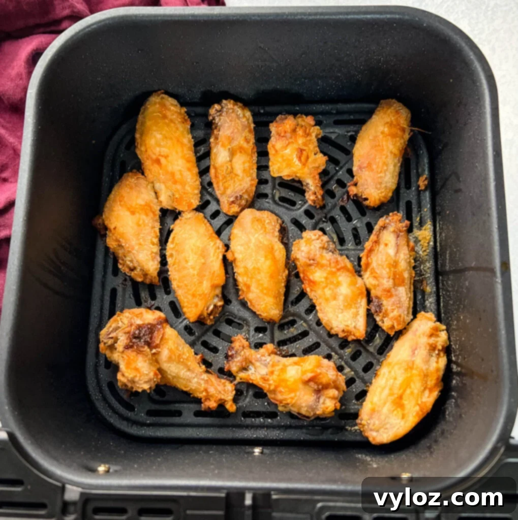Sweet Chili Chicken Wings: A Flavorful Journey 7 chicken wings cooking to golden perfection in an air fryer