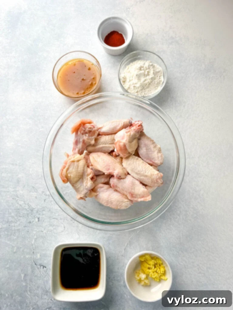 Sticky Honey Garlic Wings 3 Individual bowls containing raw chicken wings, honey, minced garlic, soy sauce, and smoked paprika – essential ingredients for the recipe.