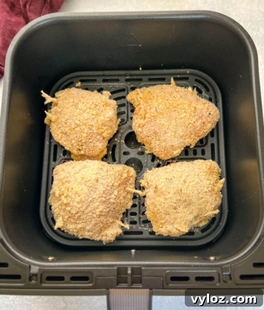 uncooked breaded stuffed mozzarella chicken breast in an air fryer
