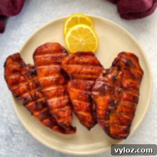 Traeger smoked chicken breasts on a plate with lemons