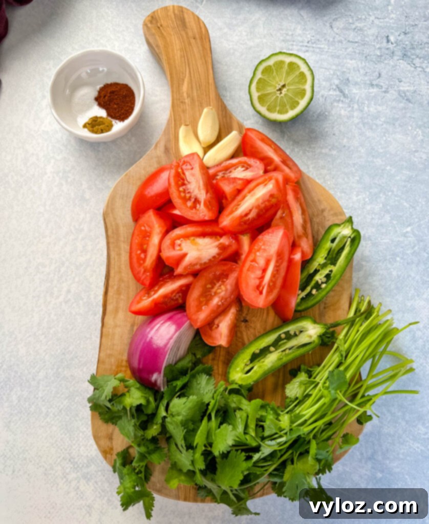 Smoky Salsa Secrets 3 Fresh ingredients for smoked salsa laid out on a surface: ripe tomatoes, a vibrant green jalapeno, fresh cilantro, garlic cloves, sliced red onion, and a lime, along with spices in small bowls.