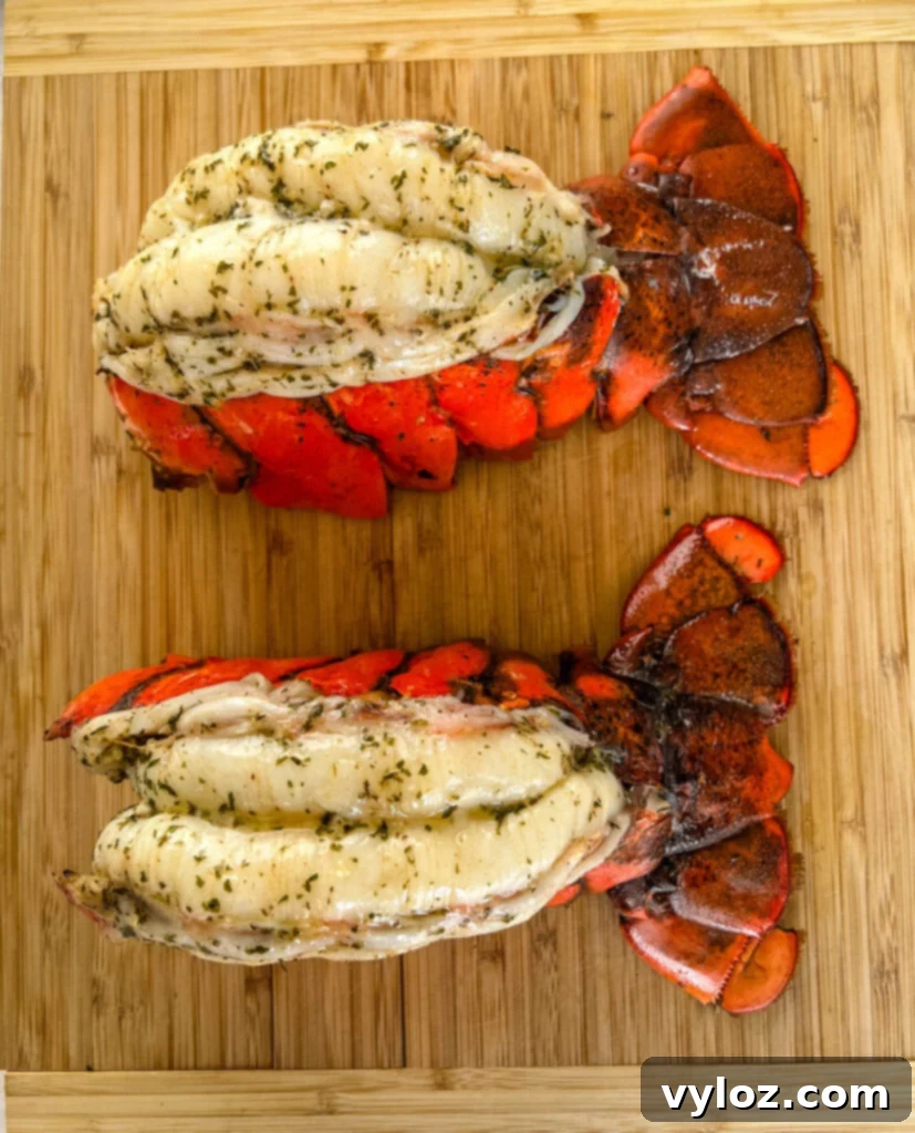 Effortless Smoked Lobster Tails 11 A stunning close-up of beautifully smoked lobster tails presented on a cutting board, garnished and ready to serve.