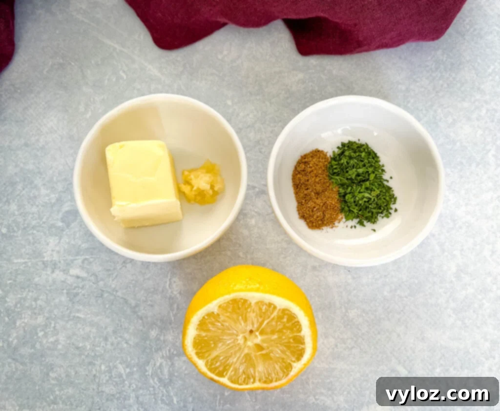 Effortless Smoked Lobster Tails 4 Separate bowls displaying fresh ingredients: rich butter, aromatic minced garlic, vibrant parsley, classic Old Bay seasoning, and bright fresh lemon.