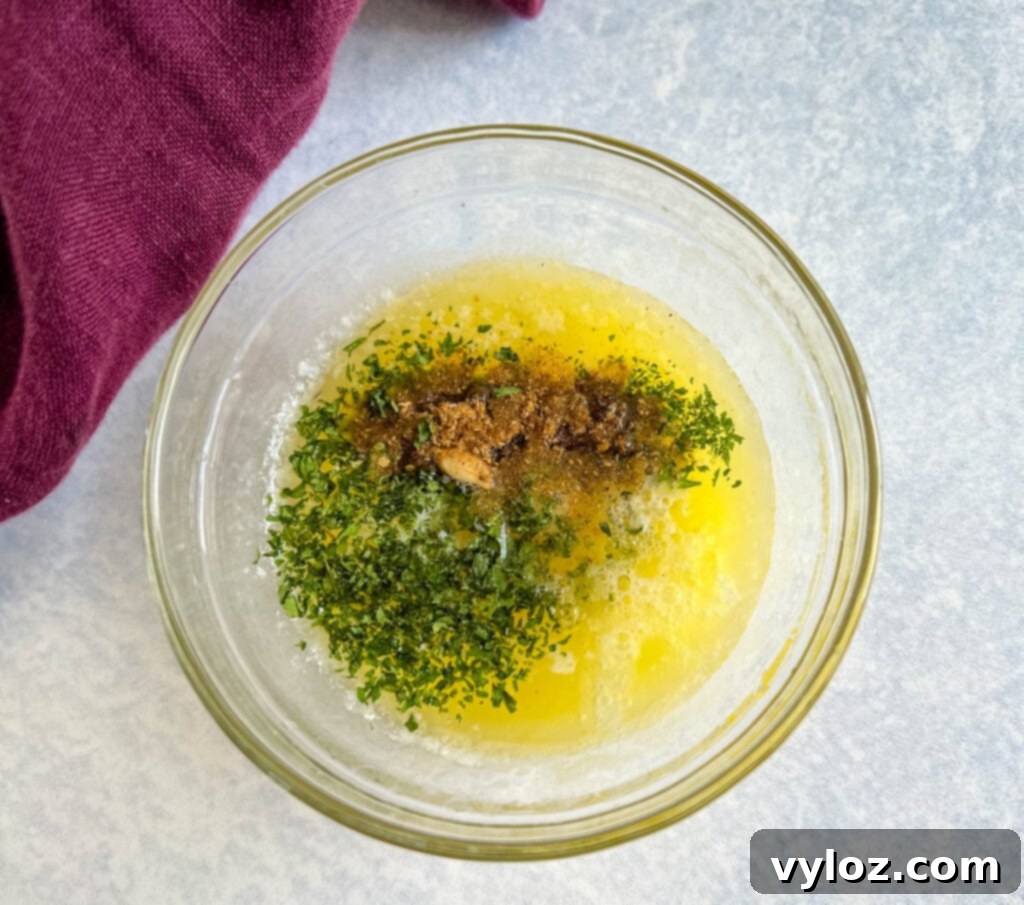 Effortless Smoked Lobster Tails 5 A glass bowl filled with the vibrant and aromatic garlic butter sauce, ready for seasoning the lobster tails.