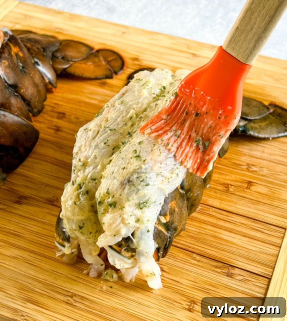 Effortless Smoked Lobster Tails 8 Raw butterflied lobster tails, generously drizzled with a rich butter sauce, laid out on a cutting board and ready for the smoker.