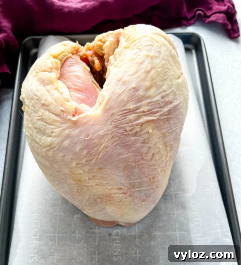 Juicy Traeger Smoked Turkey Breast 3 Raw turkey breast on parchment paper, ready for seasoning and smoking.