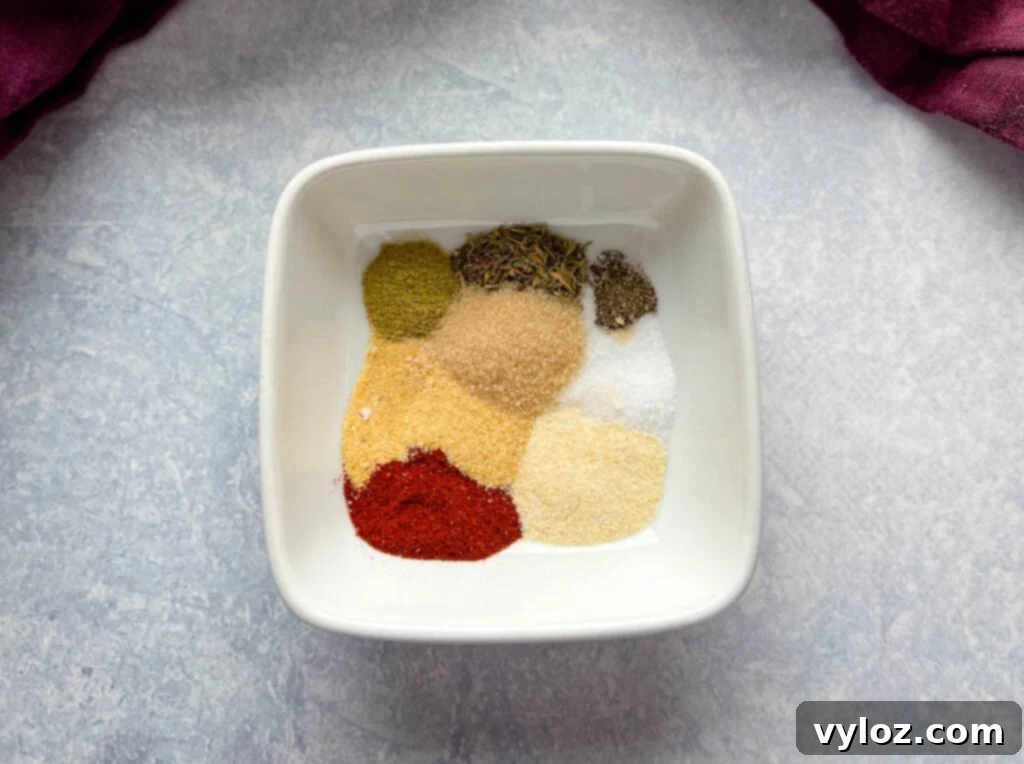 Juicy Traeger Smoked Turkey Breast 4 A white bowl filled with a homemade turkey rub blend, featuring oregano, thyme, brown sugar, smoked paprika, garlic powder, and onion powder.