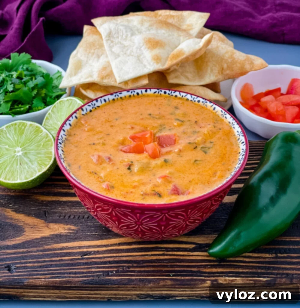 30 Must-Try Super Bowl Recipes for 2025 2 queso cheese dip in a red bowl with a plate of chips