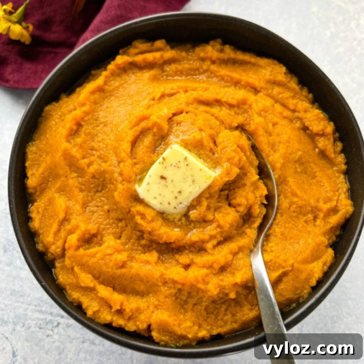 Smooth mashed sweet potatoes with brown sugar in a bowl, garnished with cinnamon