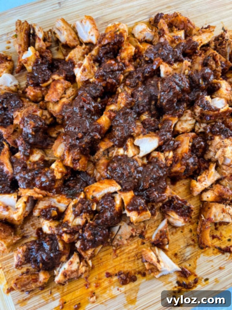 pollo asado on a cutting board with sauce